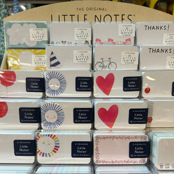 A variety of small notes arranged in a store, featuring different colors and handwritten messages for customers.