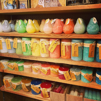 A shelf filled with jars of assorted colors and sizes, creating a visually striking and organized arrangement.