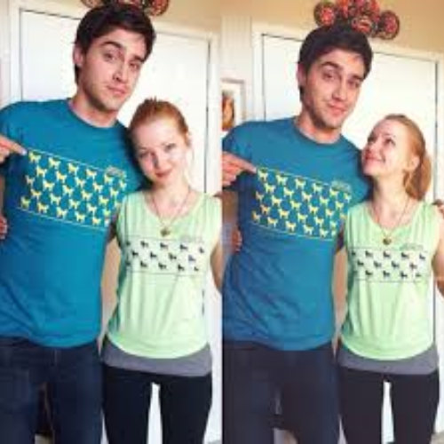 A man and woman wearing dog-themed shirts pose together indoors. She looks up smiling at him. The tone is playful and lighthearted.