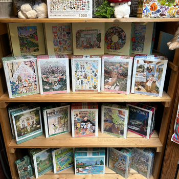 A wooden shelf displaying numerous puzzles, showcasing diverse designs and themes.