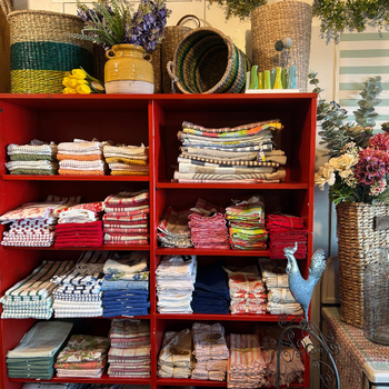 A red bookcase filled with assorted items, including books, decorative objects, and small plants.